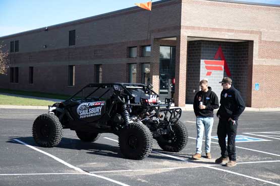 ATCC-Open-House-Fall2025_2974 ATV vehicle parked in the ATCC parking lot with two students next to it
