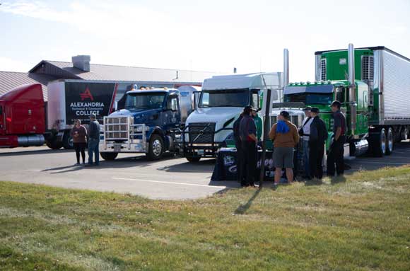 Screenshot-2026-10-02-233928 Semi trucks parked in parking lot with people gathered around