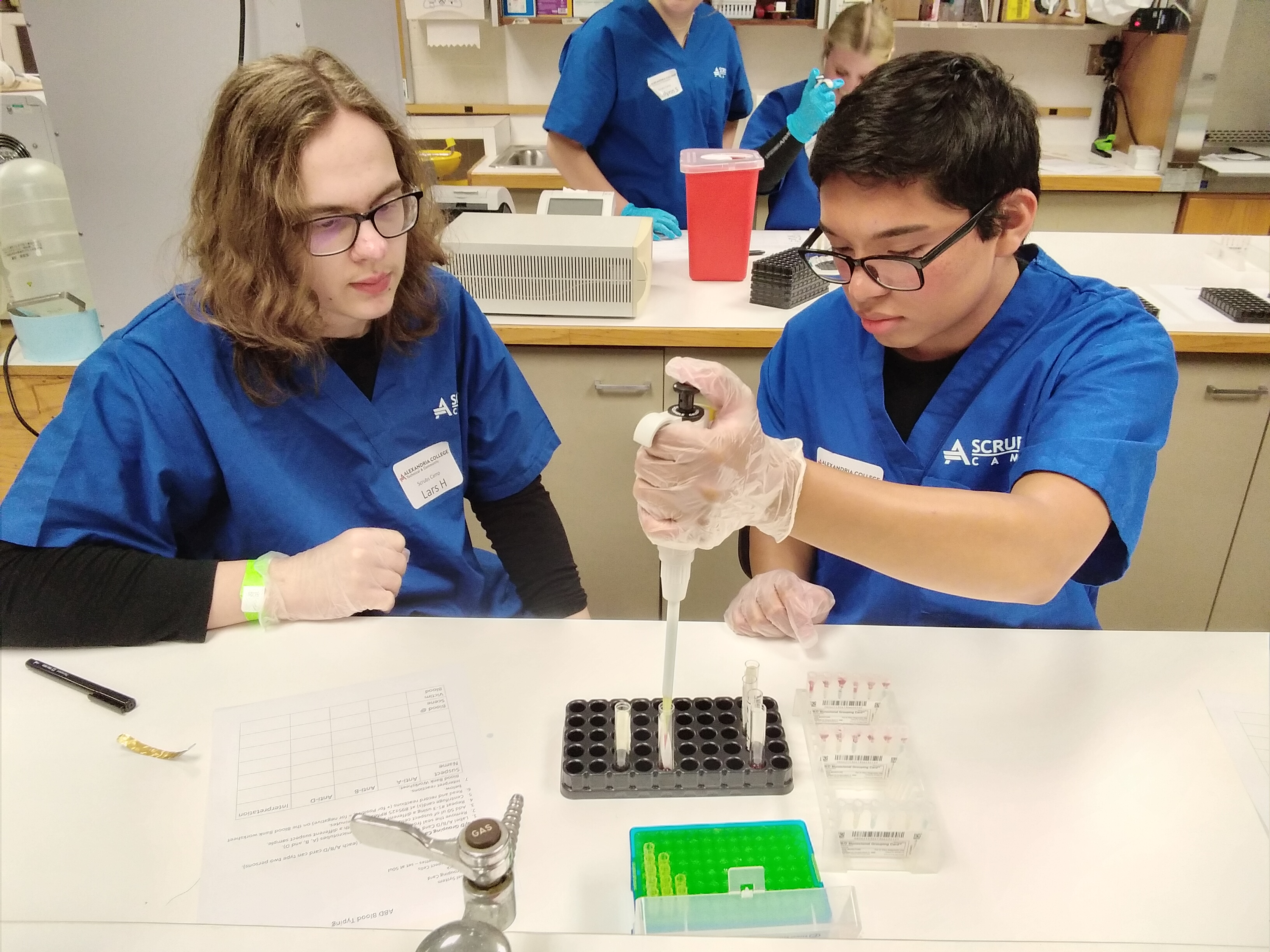 Two students taking measurements in a lab