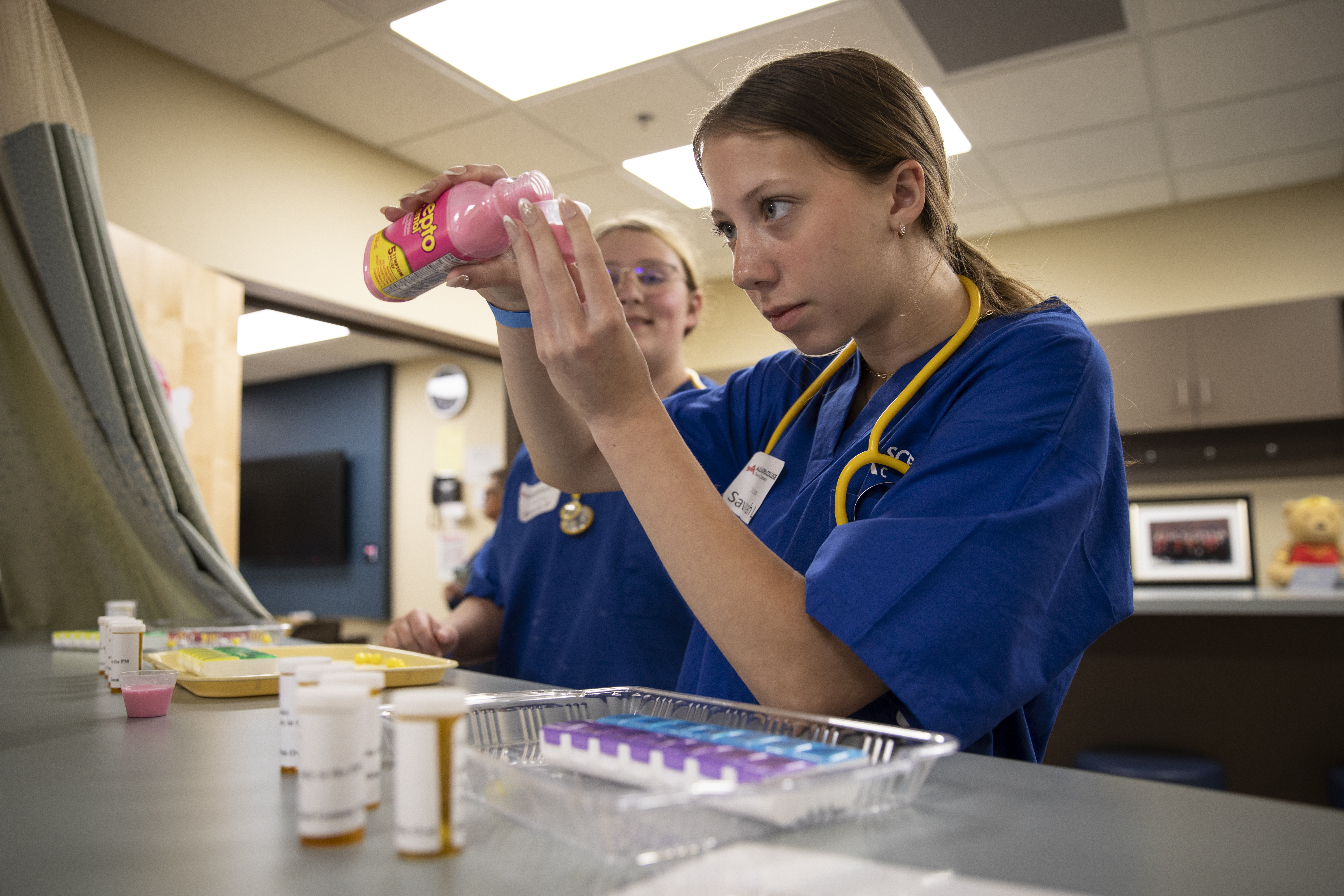 Two students measuring medications