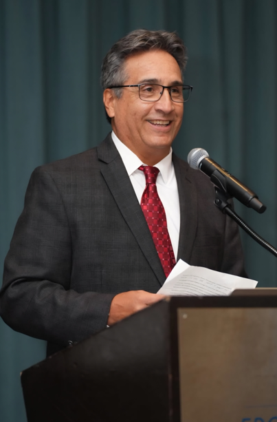 President Seymour speaks into a microphone while standing at a podium