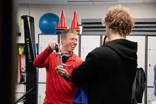 ATCC-Open-House-Fall2025_2926 Man holding grip strength testing device in his hand