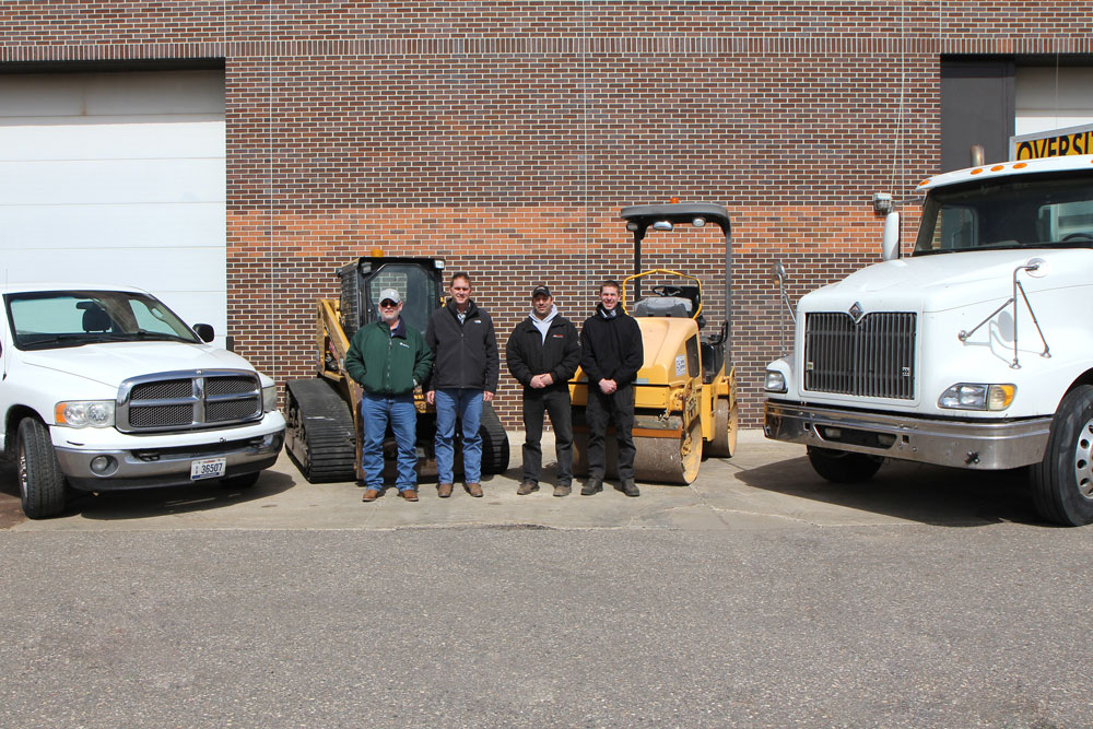 Duininck Inc representatives and Diesel instructors stand with equipment donated by Duininck
