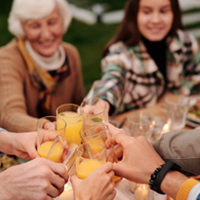 Family gathering - clinking glasses of orange juice