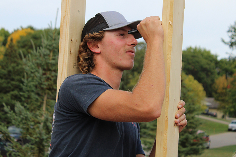 ATCC Carpentry student Gavin Ashmore writes a message to the home owner on the frame of the Legends Build project home.