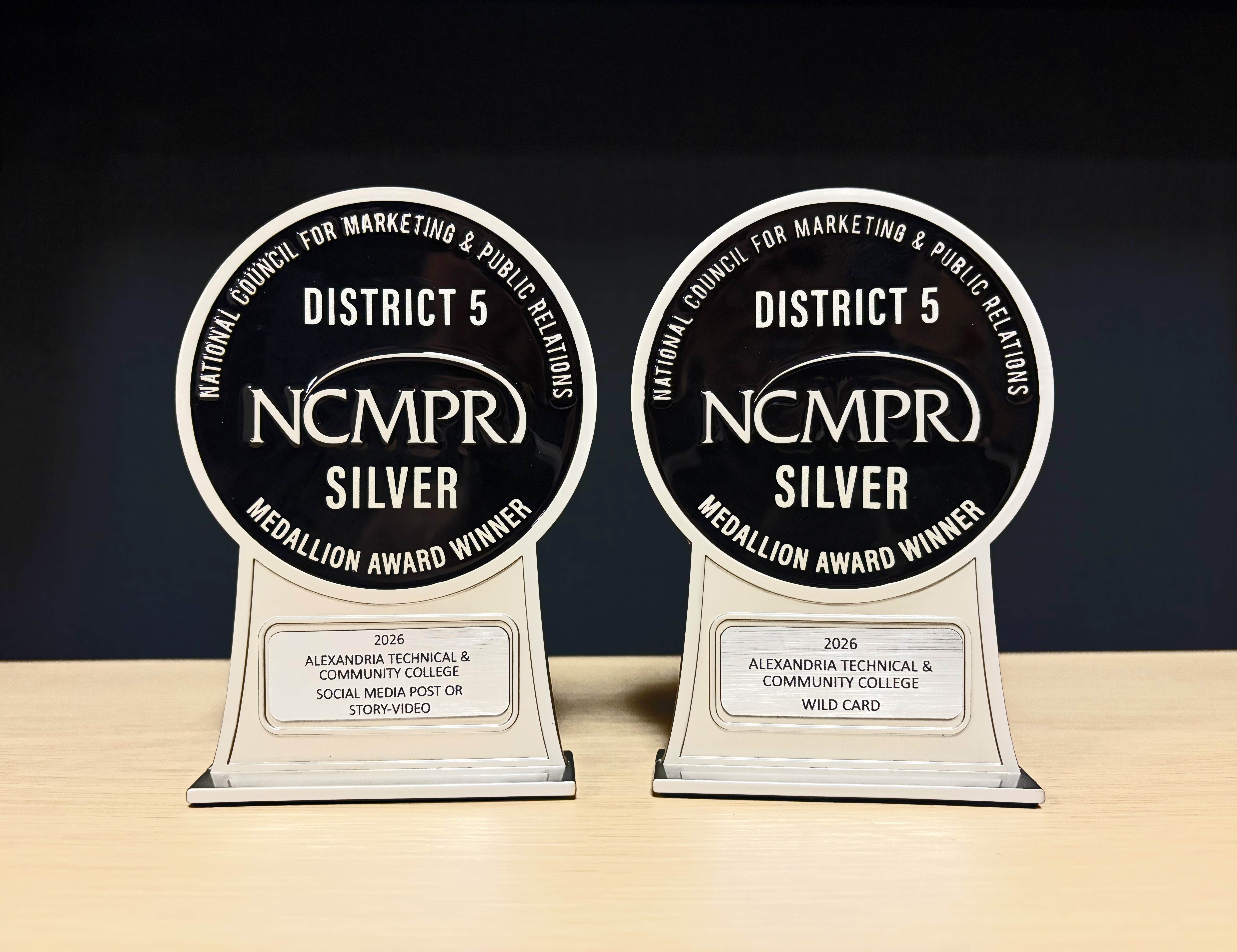 Two silver awards sit on a pale surface, each reading "District 5 NCMPR Silver"