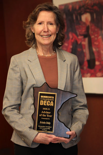 Kris Daby holds her 2021 DECA Advisor of the Year plaque