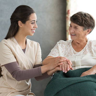 Nursing Assistant or Home Health Aide sits with elderly woman