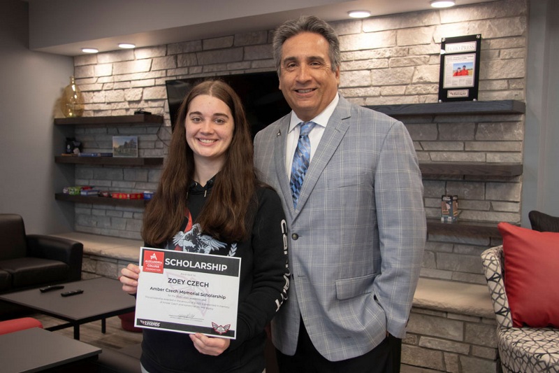 Zoey Czech (left) poses with ATCC President Michael Seymour while holding a scholarship certificate.